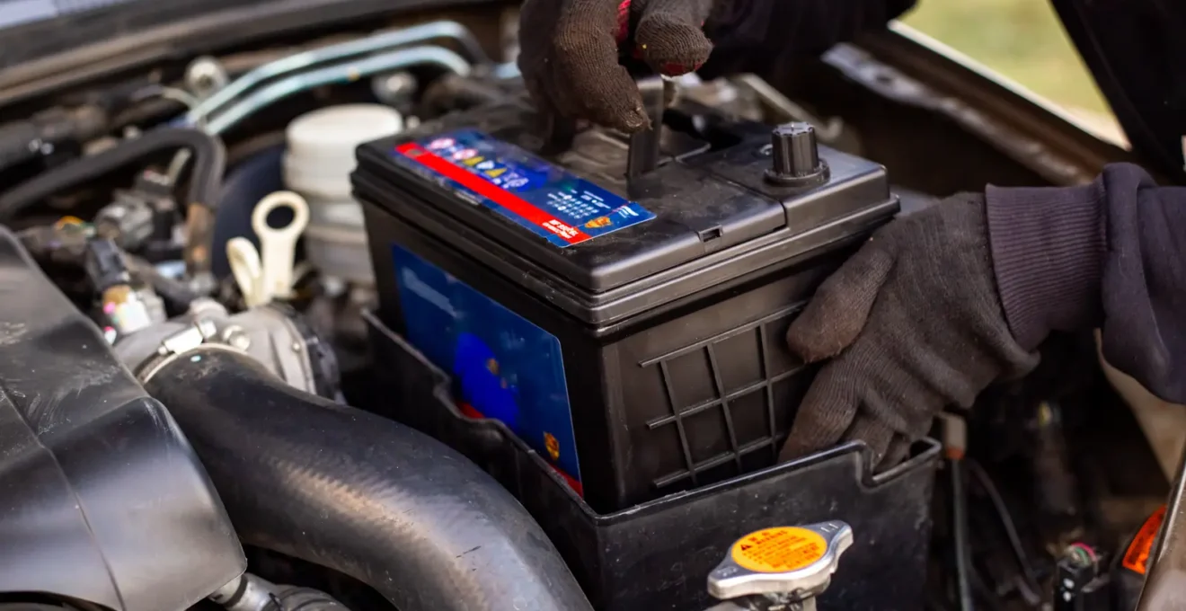 Technicien professionnel utilisant une tablette de diagnostic pour contrôler l'état de santé de la batterie d'un véhicule électrique dans un atelier spécialisé